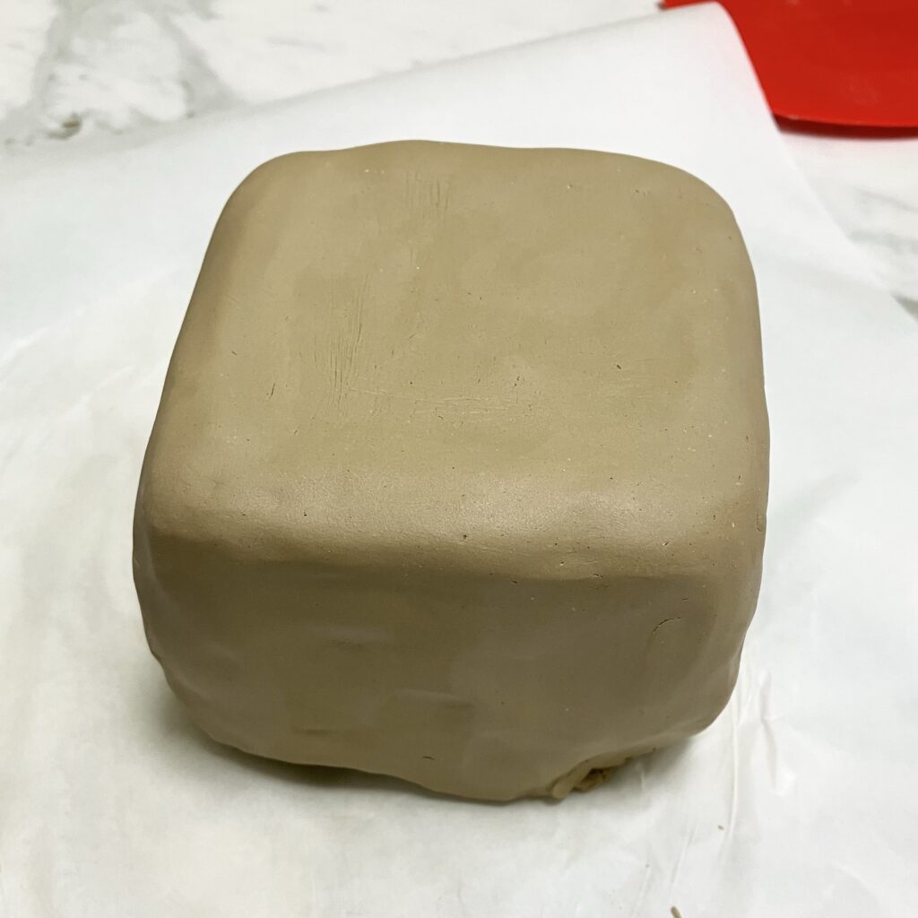 型となる容器に粘土を被せて成形する過程